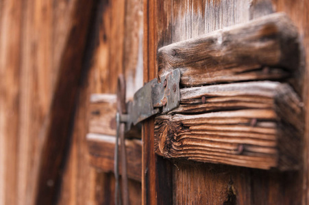 木制的门上的旧简单锁关闭与金属针用木头做的老门上的质朴闩锁