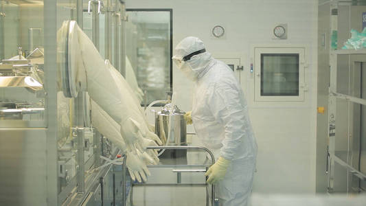制药行业。男性工人的药片包装在制药厂的质量检测。自动磁带创建包装和填料的药品。在工厂的控制