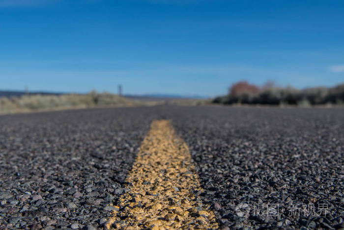 粗糙的沙漠道路上的黄色条纹低角度视图