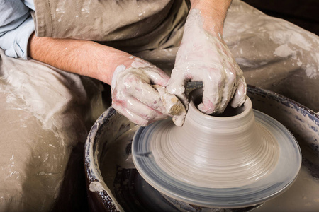 陶器 车间 陶瓷艺术概念工作特写陶工轮与原料粘土和人的手，男性手指新造型器物与海绵和水，顶视图