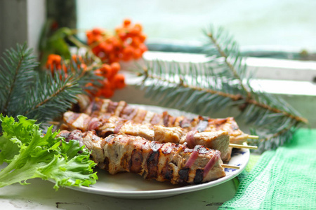 冷杉的枝条 罗文与绿叶生菜猪肉肉串烤熟在烤架上吃圣诞大餐设计器