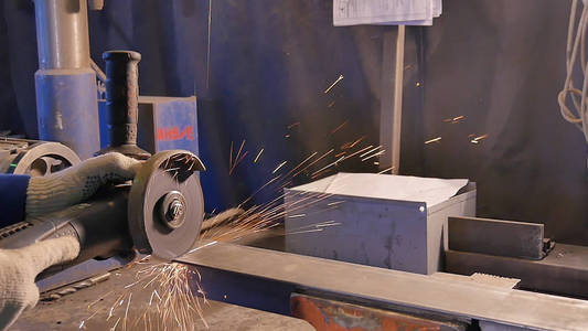 金属锯关闭.在锯切金属的生产工人.在慢动作的行业照片