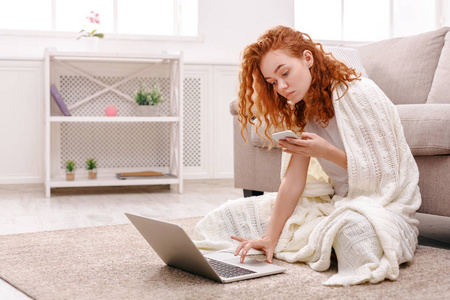舒适的家里。女孩在毛毯，一台笔记本电脑