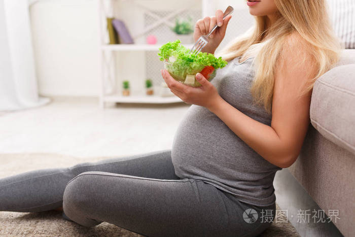 年轻孕妇吃的新鲜绿色沙拉特写