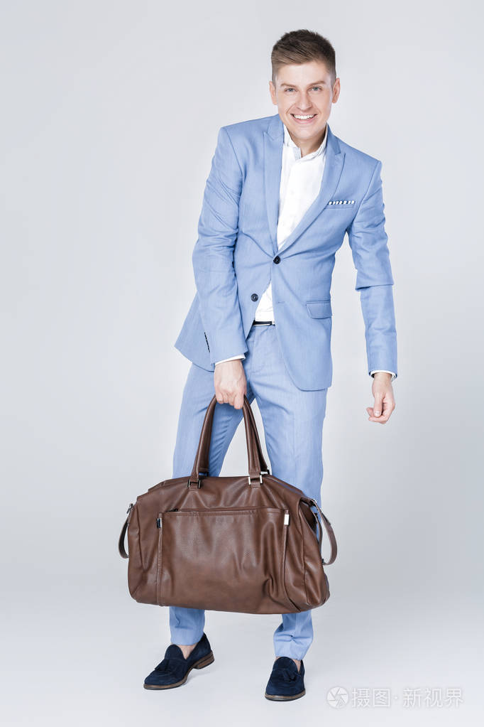 时尚蓝色西装携带皮包的男青年