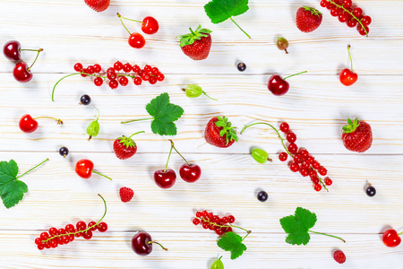 多彩的美味新鲜水果草莓，樱桃，黑醋栗和覆盆子白色木制背景上。美丽 令人愉快和健康的甜点