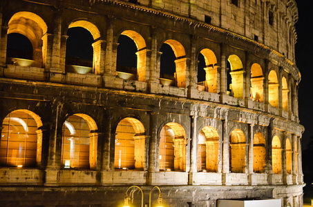 罗马，意大利。晚上世界上最受欢迎的地方之一被罗马竞技场照亮黑暗的天空下