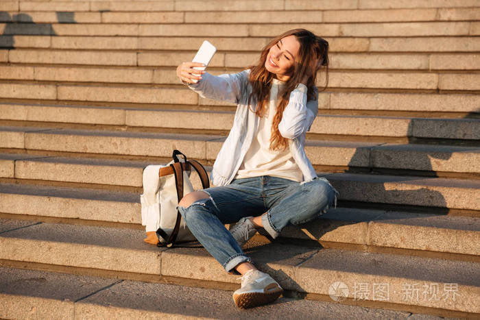 微笑在秋天的衣服坐在楼梯上的黑发女人