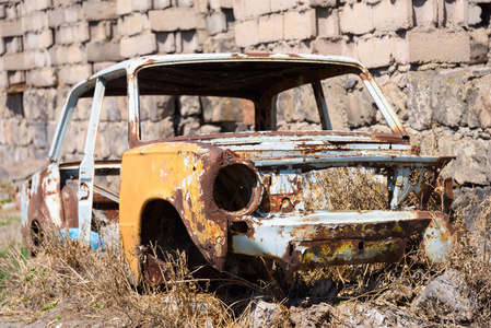 在大楼外部旁边, 一辆苏联俄罗斯汽车的被遗弃和锈迹斑斑的骨架