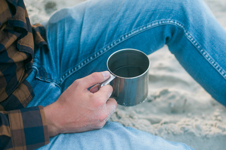 年轻人与他早上的一杯的咖啡期待海景旅游