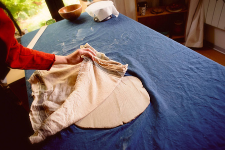 陶艺创意工场粘土卷在一块朴素的棉织物下。在织物下打开粘土的过程。.工作
