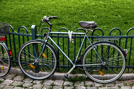 在篱笆的自行车。城市交通。自行车安全地锁定到篱笆