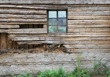 一个有窗户的村庄谷仓的烂木墙