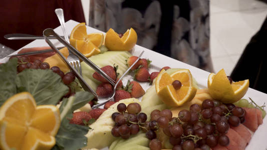 在婚礼上的不同新鲜水果自助表。水果和浆果婚礼餐桌装饰。自助婚宴水果葡萄酒香槟。婚礼餐桌装饰。樱桃
