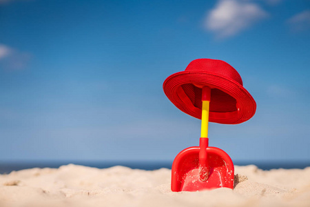 海滩上的红色铲子和草帽
