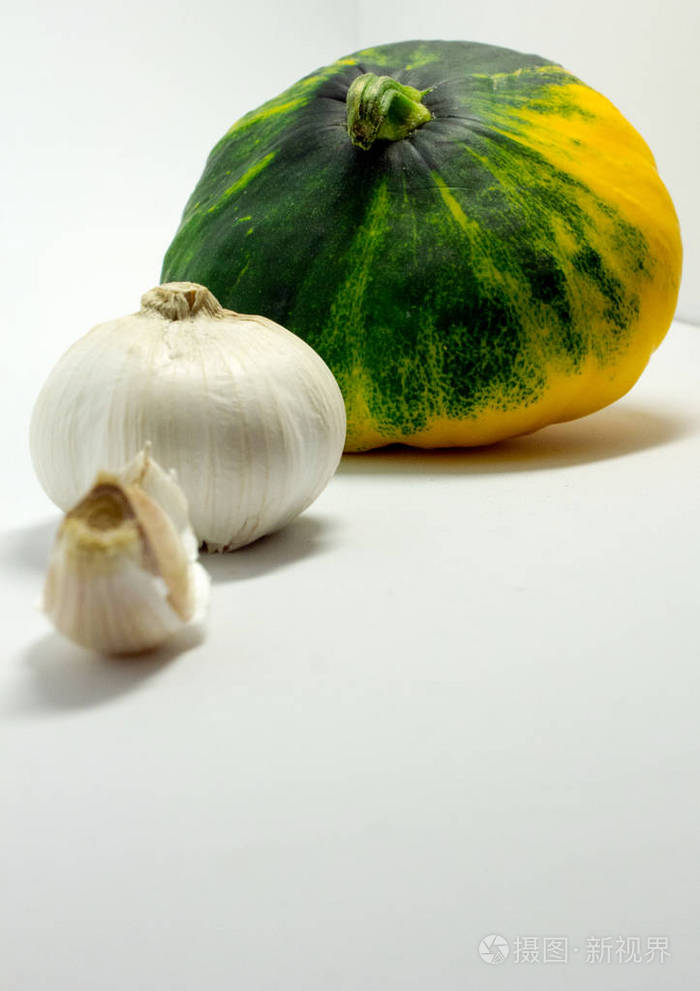 在白色背景和大蒜上的斑点南瓜