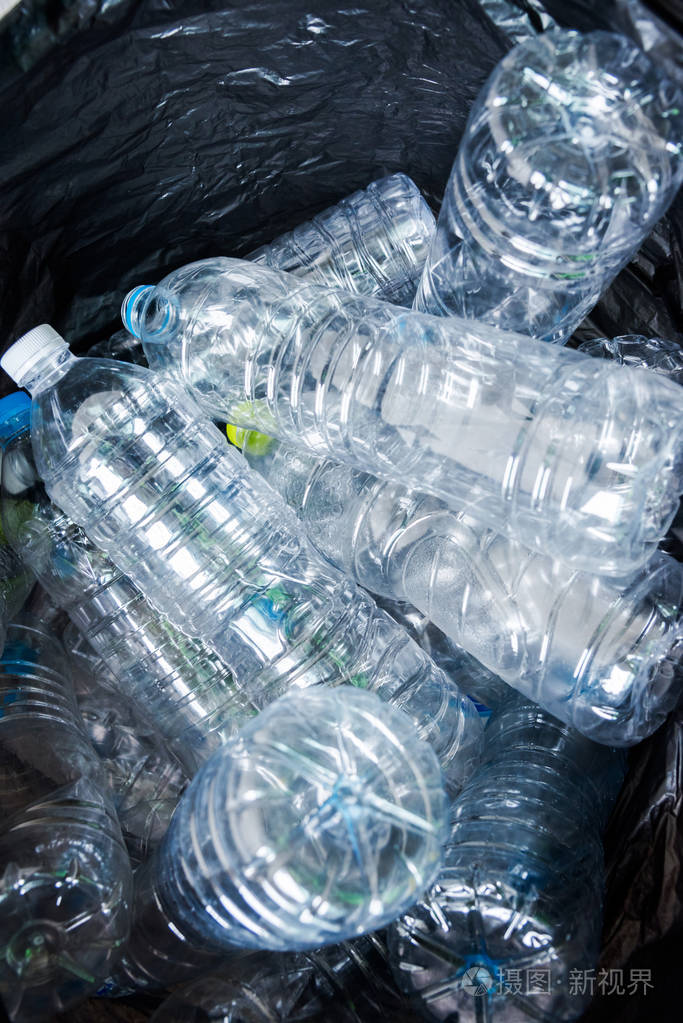 在黑色的垃圾袋里等待被采取回收塑料瓶