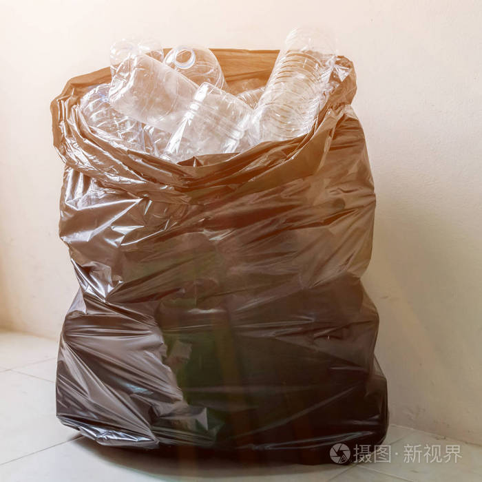 在黑色的垃圾袋里等待被采取回收塑料瓶