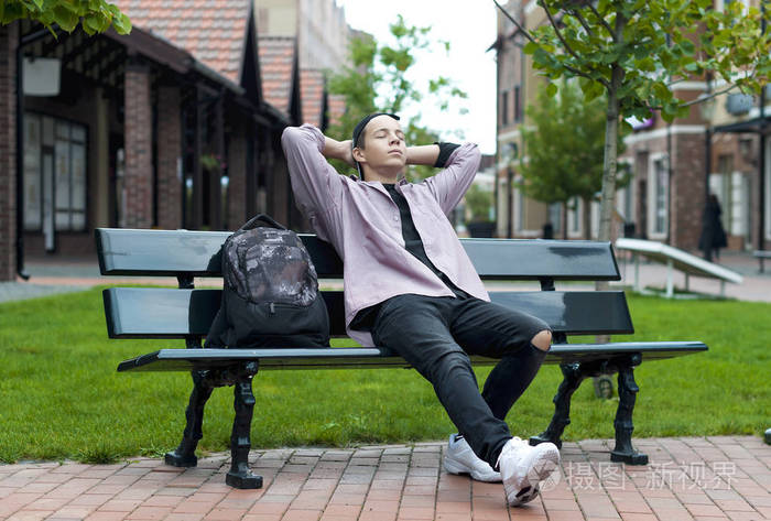 年轻男子正在休息的长椅上坐着