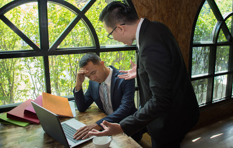 老板指责白员工负责失败/愤怒亚洲商人威胁同事/男性工人在工作场所