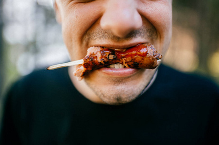 梦见死人像匡面部表情的人厌恶地吃烤香肠室外.