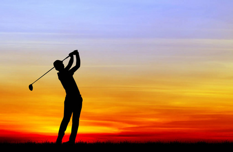 在美丽的日落期间打高尔夫球的剪影高尔夫球手