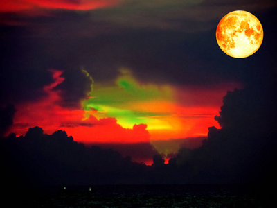 在海的黑暗天空上的血月亮和五颜六色的云
