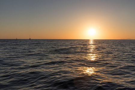 从海上可以看到美丽的日落。与两个双体船圣托里尼