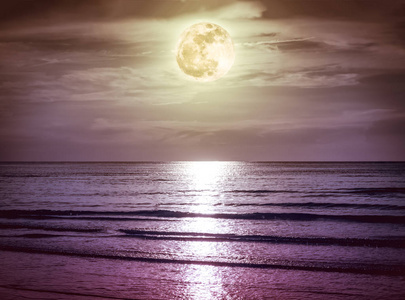色彩斑斓的天空，乌云与皎洁的月亮在海景