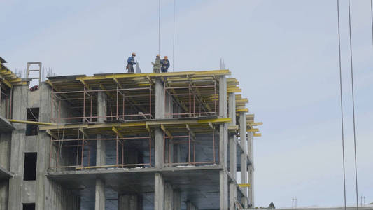 建筑地盘工程对蓝蓝的天空。一栋公寓楼建筑工地的工人