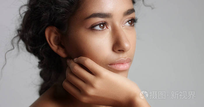 幸福安详年轻女人美丽橄榄色的皮肤和卷曲的头发理想的皮肤和棕色的