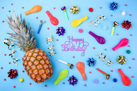 生日快乐背景。节日的菠萝 方五彩纸屑 气球 彩带 蓝色背景上的装饰。丰富多彩的庆祝活动背景