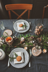 喜庆的圣诞和新年表在斯堪的纳维亚风格自然和白色色调仿古手工制作详细的设置。用餐的地方装饰着松果 分支机构和蜡烛