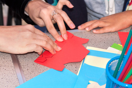 母亲帮助孩子去折叠彩纸，从到 t 图