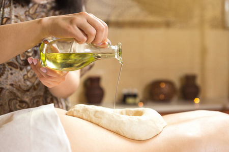 女人在有香薰按摩精油，女人享受 spa，按摩技巧，阿育吠陀油按摩治疗的 spa 水疗背部按摩，按摩水疗沙龙的女孩阿育吠陀草药