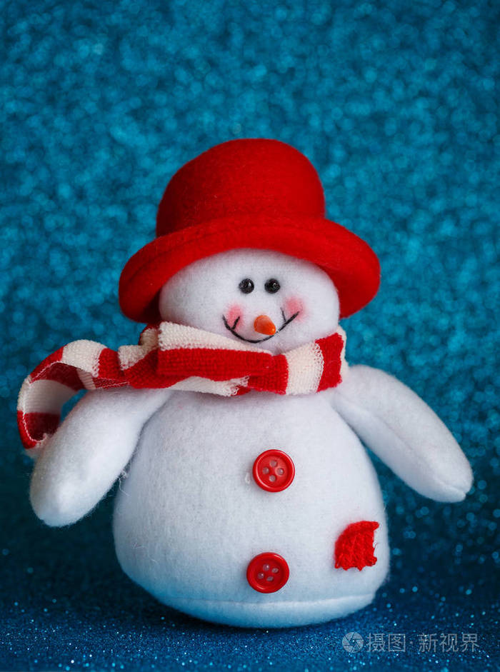微笑雪人玩具穿着围巾和帽子上抽象的散景背景