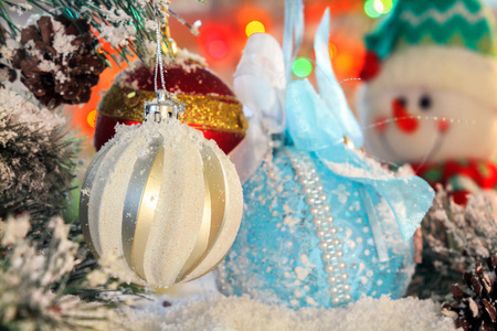 五颜六色的气球挂在反对一个圣诞雪人和彩灯的圣诞树的雪覆盖分支