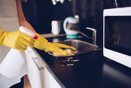 清洗厨房橱柜用海绵的女人