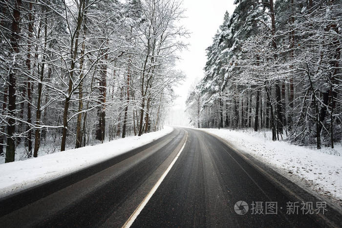 冰雪覆盖的森林沥青路