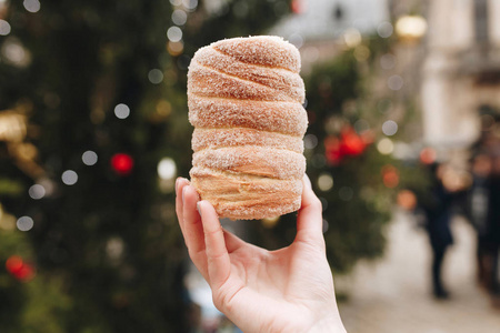 在女孩的手，假日背景 Trdelnik