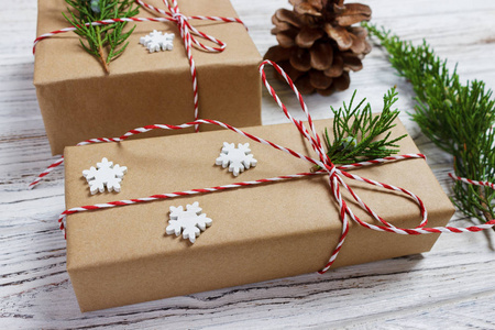 圣诞节或新年礼物天然彩色纸裹起来，用传统的圣诞麻绳和冷杉装饰白色背景上的树枝