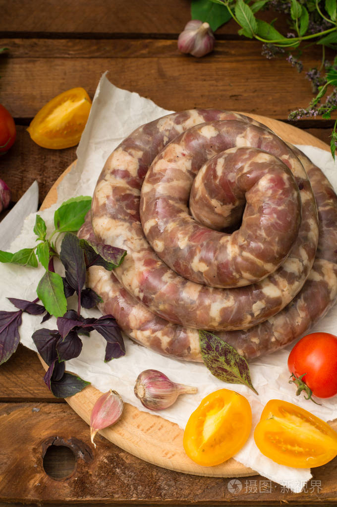 在木制背景的白色盘子里生鲜香肠顶部视图特写