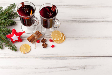 冬天水平酝酿葡萄酒的旗帜。热红酒和香料，树，毛毡装饰木制背景上的眼镜
