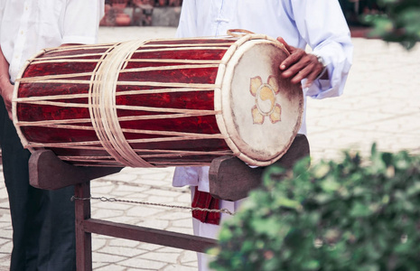 这位音乐家越南鼓.这位音乐家握着鼓,玩它照片