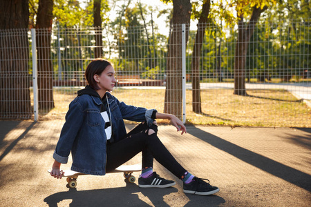 一个女孩坐在滑板公园里