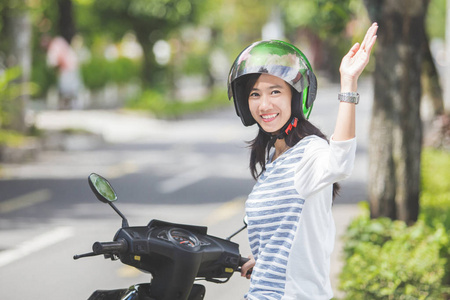 在摩托车挥动手上的女人图片