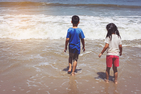 小男孩和女孩在沙滩上玩