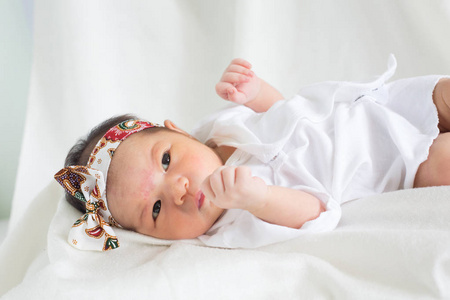 可爱的婴儿婴儿两周睡在床上，白色背景概念国际日的女童苹果眼基督教洗礼新生儿婴儿