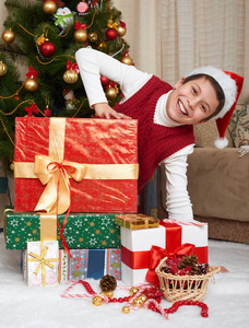 接近的圣诞树和礼品盒 快乐的假期和冬季庆典，穿红衣服的男孩