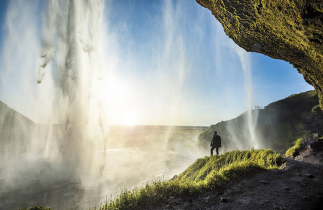 游客站在 Seljalandsfoss 在冰岛南部，Seljalandsfoss，冰岛最著名的瀑布之一